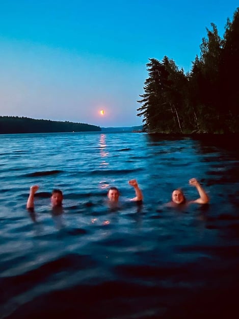 Three founders of RDT swimming in a Finnish lake in moonlight